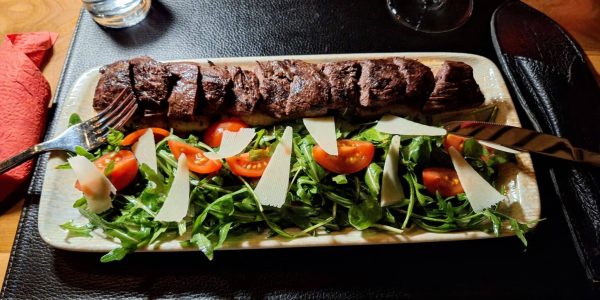 Steak tranché avec roquette, tomates et parmesan